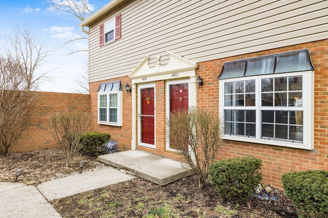 property entrance featuring brick siding