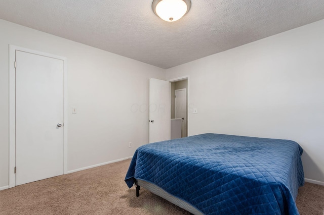 bedroom featuring carpet, baseboards, and a textured ceiling