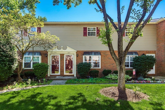 view of front of house with brick siding and a front yard