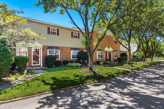 view of front of home with a front yard and brick siding