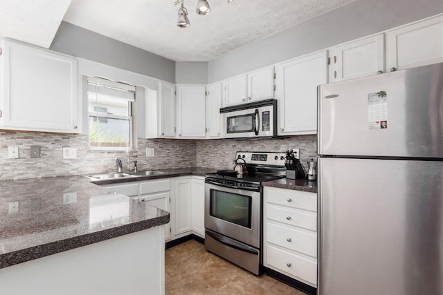 kitchen featuring stainless steel appliances, white cabinets, a sink, and decorative backsplash