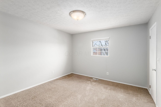 carpeted empty room with a textured ceiling, visible vents, and baseboards