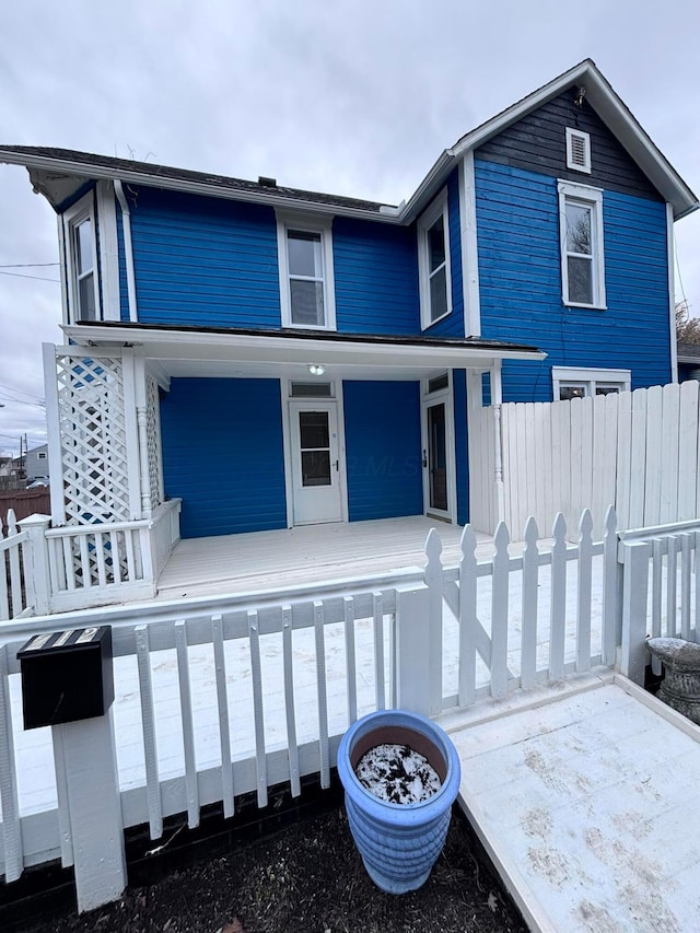 view of front of home with covered porch and fence