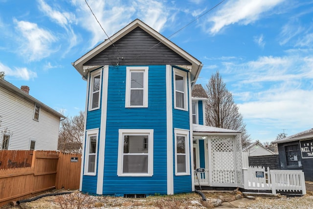 back of property featuring covered porch and fence