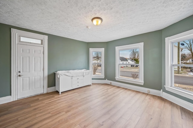 interior space featuring baseboards, a wealth of natural light, and light wood-style floors