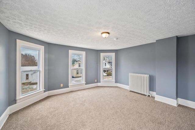 unfurnished room with baseboards, carpet, and radiator