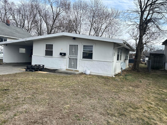 view of front of home with a carport, fence, and a front lawn