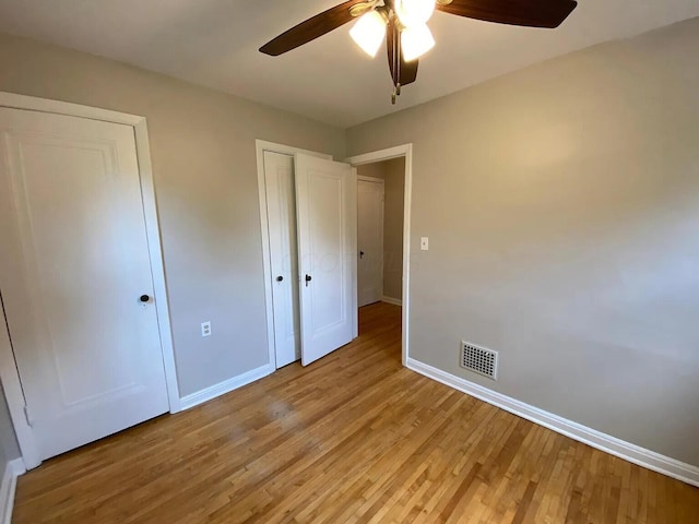 unfurnished bedroom with light wood-style floors, baseboards, a closet, and ceiling fan