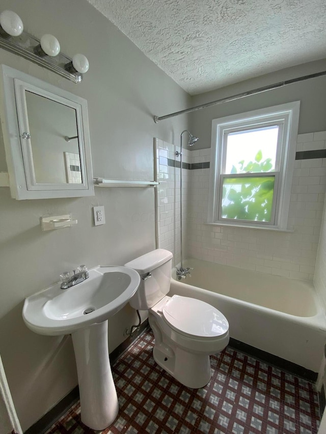 full bath with shower / tub combination, toilet, and a textured ceiling