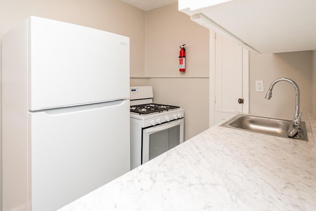 kitchen featuring white appliances and a sink