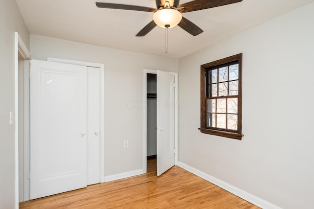 unfurnished bedroom featuring light wood-style flooring, a ceiling fan, and baseboards