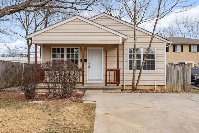 bungalow-style house featuring covered porch and fence