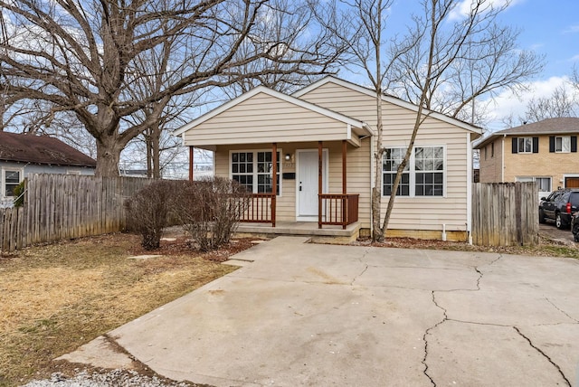 bungalow-style home featuring covered porch and fence