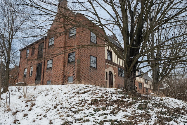 view of snowy exterior with brick siding