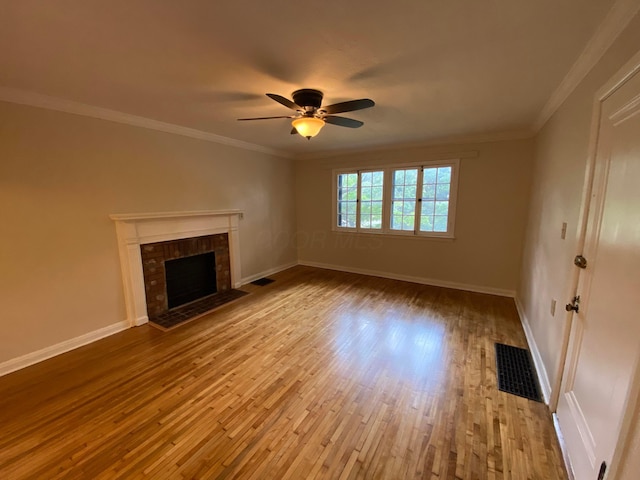 unfurnished living room featuring a fireplace, visible vents, baseboards, ornamental molding, and wood-type flooring