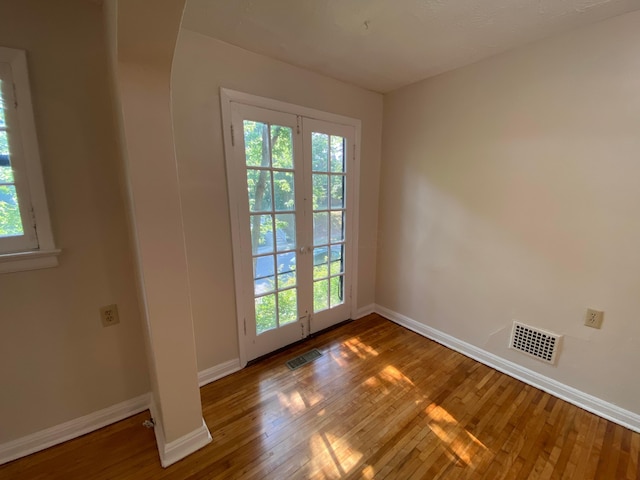 doorway to outside featuring a wealth of natural light, hardwood / wood-style floors, and visible vents