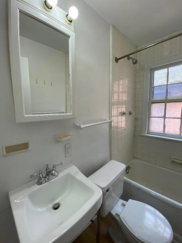 bathroom with toilet, shower / washtub combination, and a sink