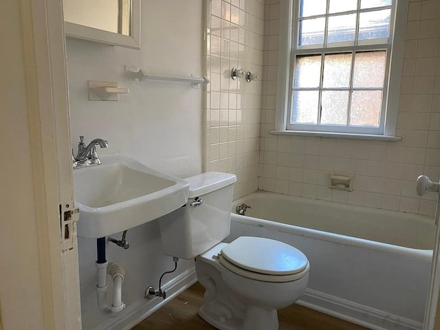 full bathroom with wood finished floors, shower / washtub combination, a sink, and toilet