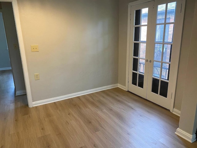 unfurnished room with french doors, wood finished floors, and baseboards