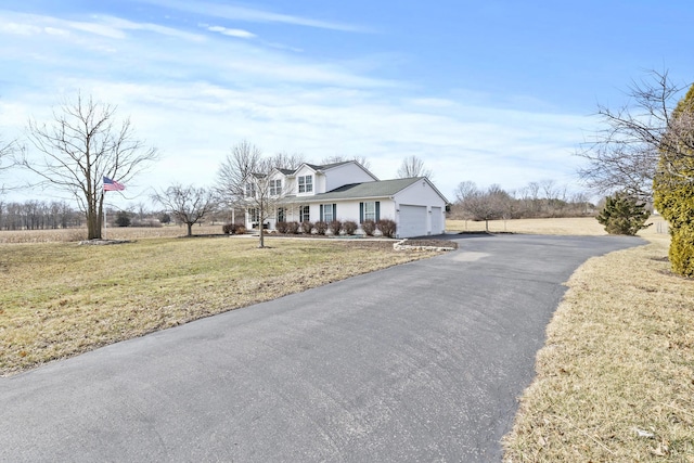 view of front facade featuring driveway, an attached garage, and a front yard