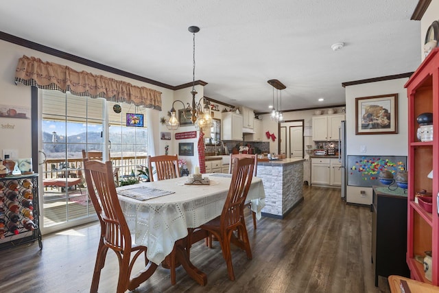 dining area featuring crown molding, a chandelier, and dark wood-style flooring