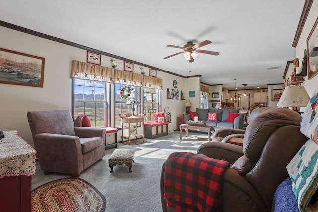 living area with ceiling fan, carpet floors, and ornamental molding