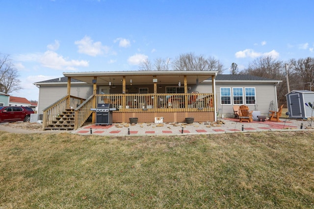 back of property with a yard, a patio area, a shed, an outdoor structure, and a wooden deck