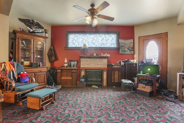 living area with ceiling fan, carpet floors, and a fireplace