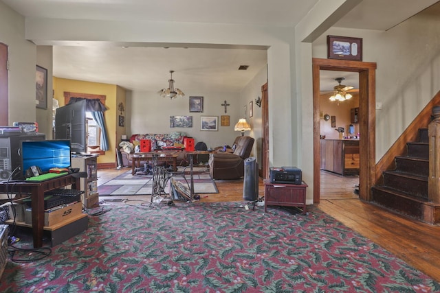 living area with ceiling fan, stairway, and wood finished floors