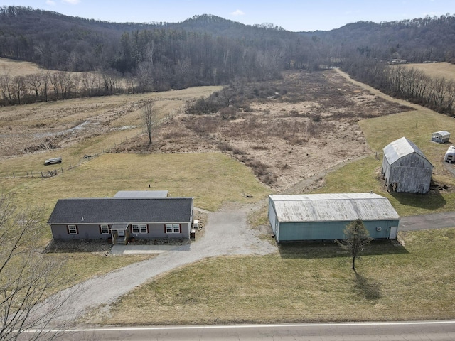 birds eye view of property featuring a rural view and a wooded view