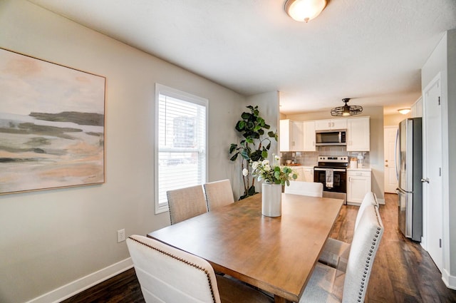 dining room featuring dark wood-style floors and baseboards