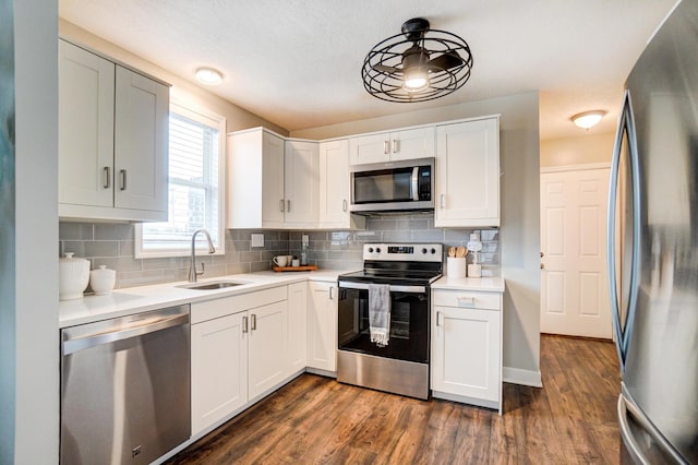 kitchen with dark wood-style floors, backsplash, stainless steel appliances, and a sink