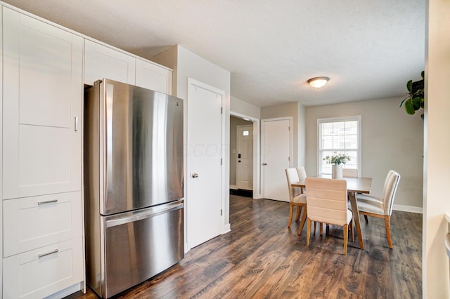 dining space featuring dark wood-style floors and baseboards