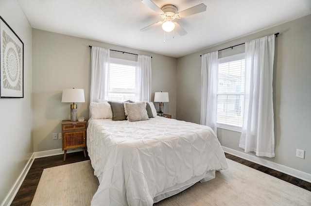 bedroom with dark wood finished floors, ceiling fan, and baseboards