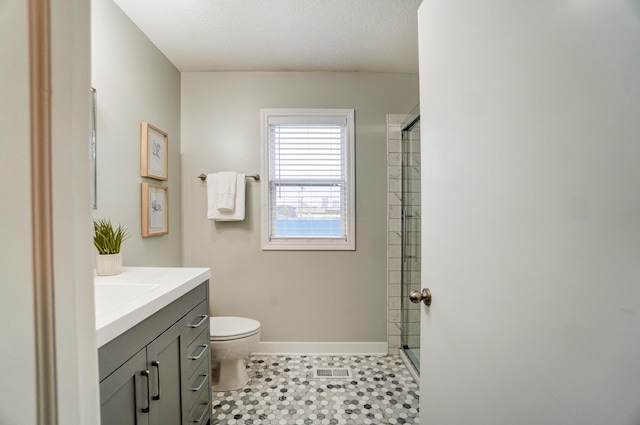 bathroom featuring an enclosed shower, visible vents, toilet, baseboards, and vanity