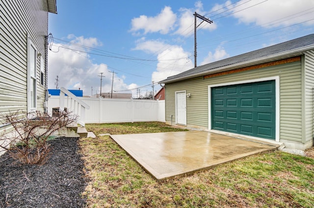 garage featuring driveway and fence