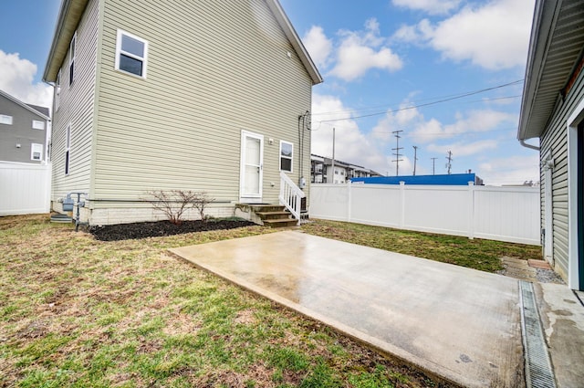 exterior space featuring entry steps, a patio area, fence, and a lawn