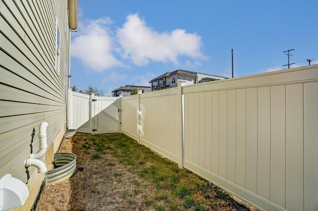 view of yard with a fenced backyard and a gate