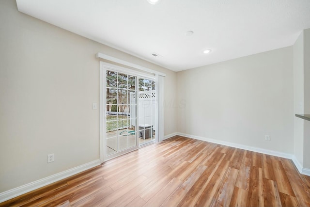 empty room featuring baseboards and light wood finished floors