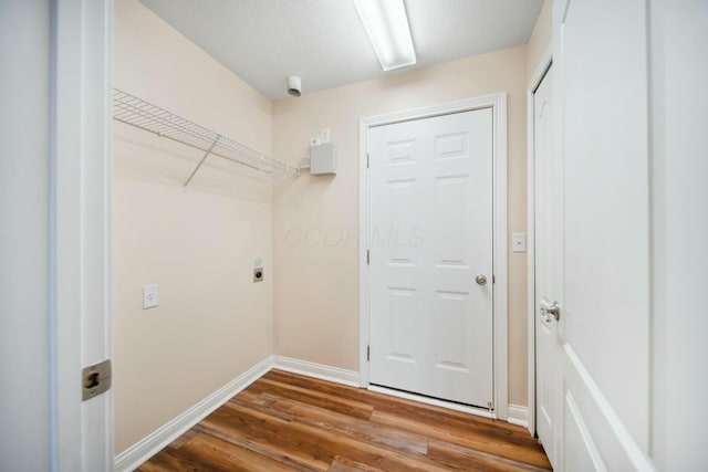 washroom featuring laundry area, baseboards, electric dryer hookup, and wood finished floors