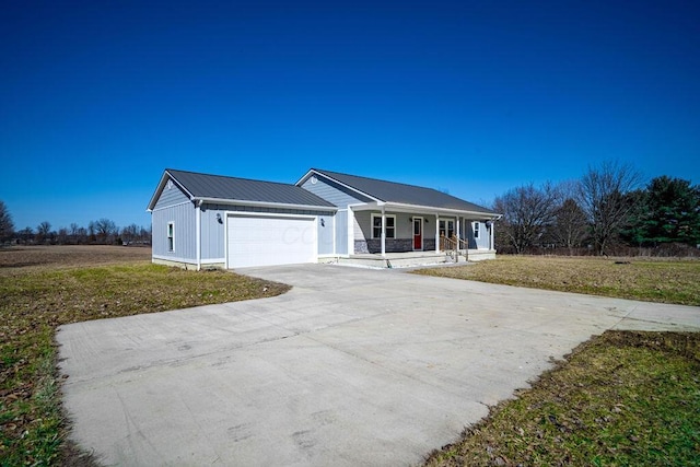 single story home featuring covered porch, concrete driveway, a front lawn, a garage, and metal roof