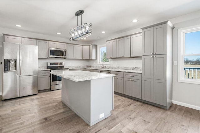 kitchen featuring light wood-type flooring, stainless steel appliances, and gray cabinetry