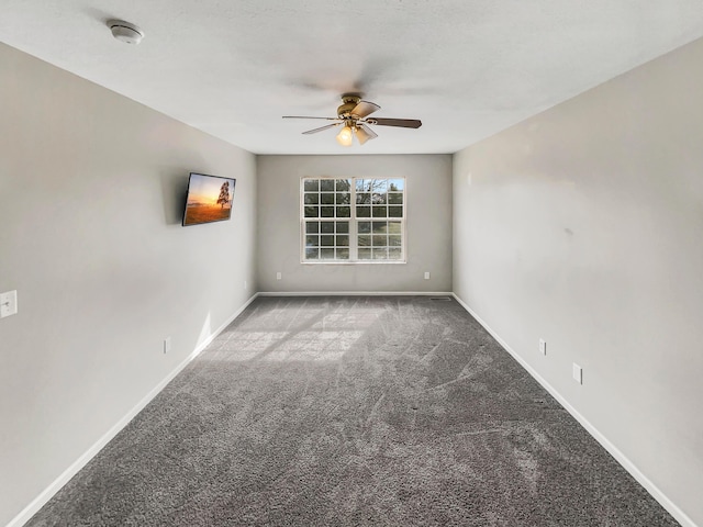 carpeted spare room with ceiling fan and baseboards