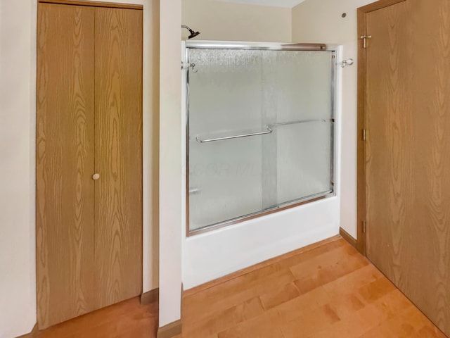 bathroom featuring combined bath / shower with glass door and wood finished floors