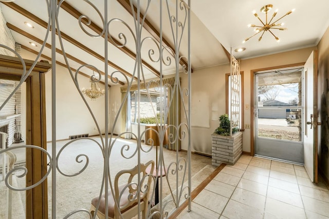 entrance foyer with visible vents, an inviting chandelier, light tile patterned flooring, vaulted ceiling, and baseboards