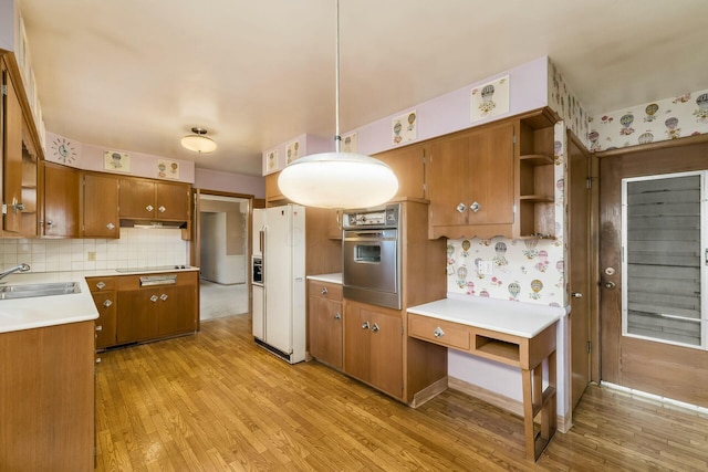 kitchen featuring brown cabinets, open shelves, stainless steel oven, a sink, and white fridge with ice dispenser