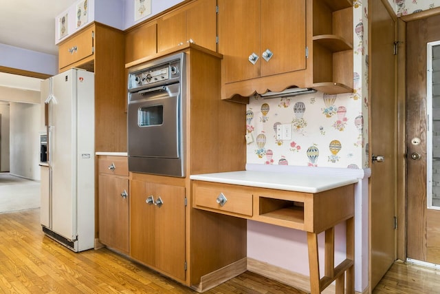 kitchen featuring light wood finished floors, white fridge with ice dispenser, open shelves, and oven