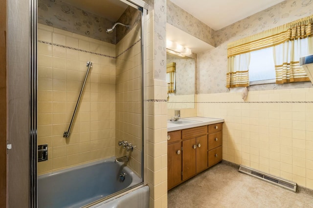 bathroom featuring wallpapered walls, visible vents, wainscoting, bathtub / shower combination, and tile walls