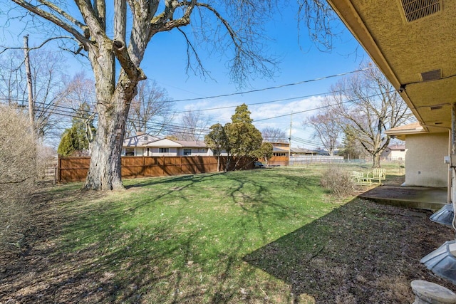 view of yard with a patio, fence, and visible vents