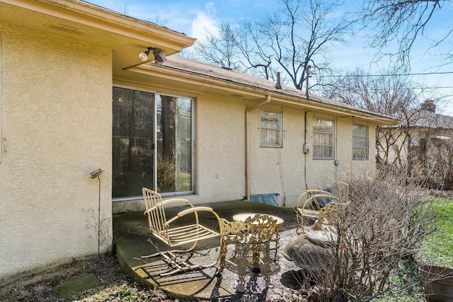 rear view of property with a patio area and stucco siding